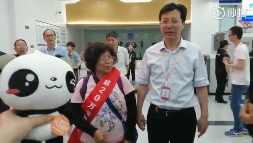 玉環市常務副市長柯壽健為第20萬位遊客頒發綬帶——一位來自臺中的阿嬤!圖片