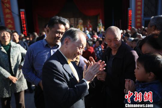 15日，新黨主席鬱慕明來到山西省晉城市高平市神農鎮祭拜炎帝。圖為鬱慕明和當地等待看戲的兒童拍手。　　　李強 攝