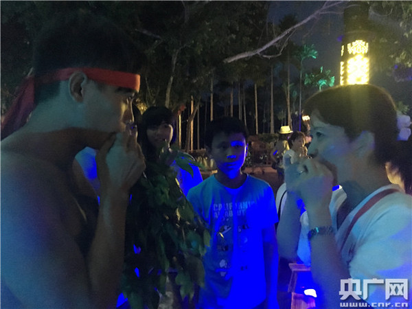 黎族阿哥交臺灣鄉親吹葉笛。(央廣網記者 李展鴻 攝)