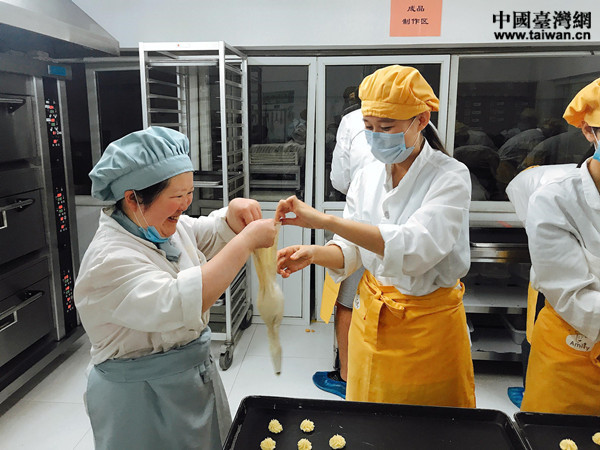 “喜憨兒”慧慧在幫助實習生魏曼芯調整工具，齊心協作，擠出的曲奇餅幹形狀標準，精致均勻