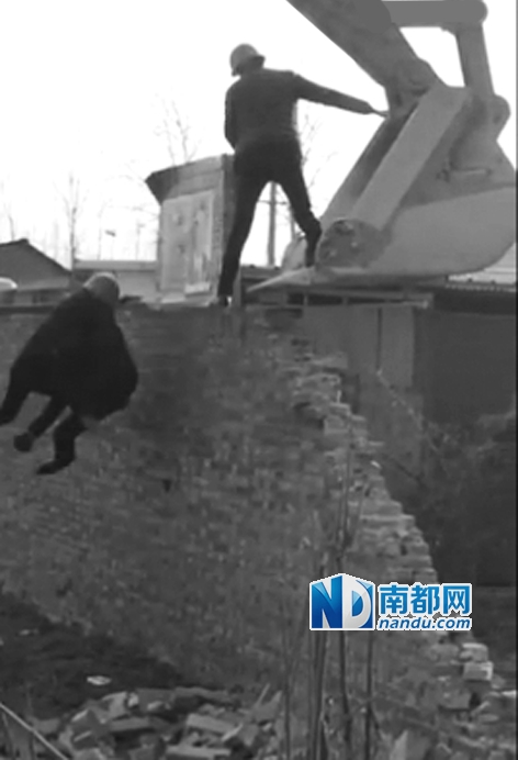 李戰勝被人抱著從牆上摔下。