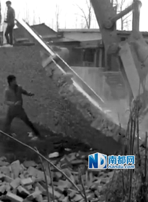 一名年輕男子企圖衝到牆邊，但未能阻止挖掘機。 視頻截圖