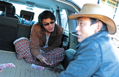 一收購商坐在車里和牧民交易蟲草，一棵上等的新鮮蟲草收購價通常在100元左右。