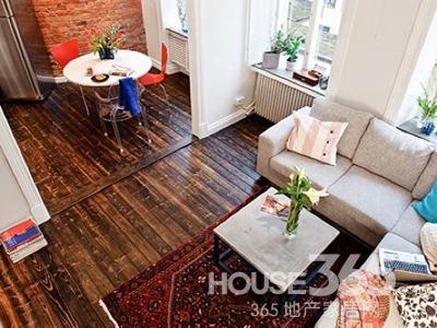 從臥室所處的夾層望下來，廚房和客廳相連，較高的空間顯得十分開闊。屋子里大部分面積都在這里。