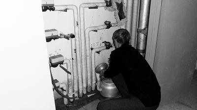 居民在一層的供水管道臨時接水。 居民在一層的供水管道臨時接水。