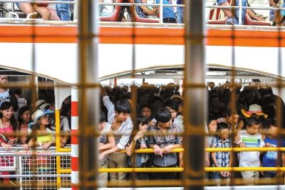 景區“超載” 10月2日，福建省廈門市，下午4點半，從鼓浪嶼回到廈門島的遊客擠滿了輪渡。廈門市共動用23艘載客量600人的輪渡應對人潮，每艘輪渡，相當于15輛大巴車的載客量。當日遊客量達7.9萬，遠超過該景區6萬遊客承載量。圖/CFP