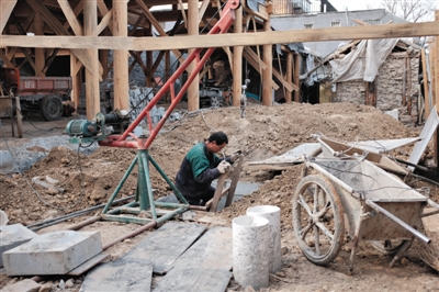 東城區北鑼鼓巷與小經廠胡同之間一處四合院內，工人進入已經挖好的地下室內施工。