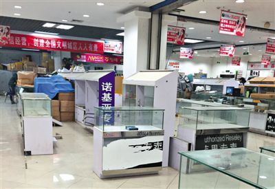 中關村e世界一層，商戶撤離後，剩下空置的櫃臺。近日市場貼出放假公告，這里今後將不再是電子賣場。新京報記者 鄧琦 攝