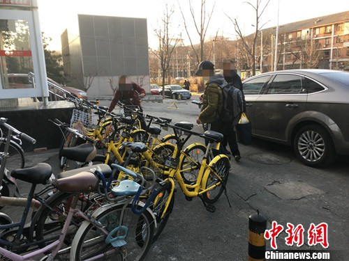 在北京街頭的一處共享單車停車點，有小孩在嘗試解鎖。湯琪 攝