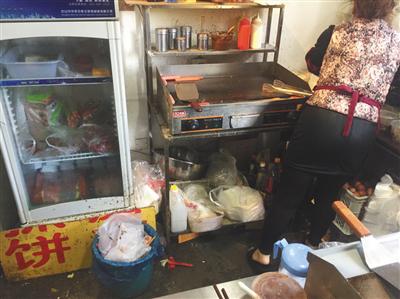 同時入駐了三家外賣平臺的“臺灣手抓餅”店內，老板娘正在加工食物，店內衛生條件差。後該店被查出無證經營。新京報記者 張越攝