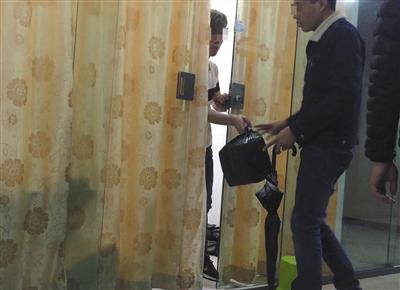 3月7日傍晚，廣州市越麗（國際）皮具城，拉著落地窗簾的檔口開了一條縫，“跑貨仔”拎著裝有高倣名牌包的黑色塑料袋“串貨”。