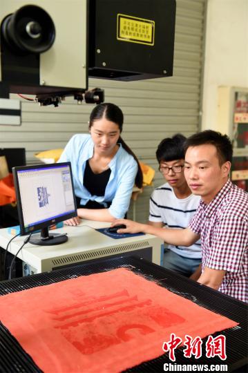 圖為學生用激光打標機在雕刻圖案 王國海 攝