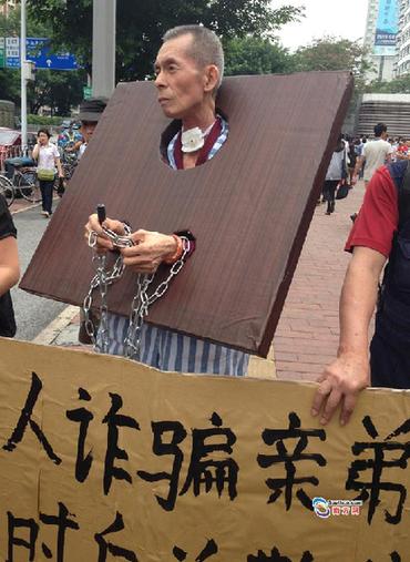 老人8年前騙親弟近億資產 今患癌戴枷鎖街頭懺悔