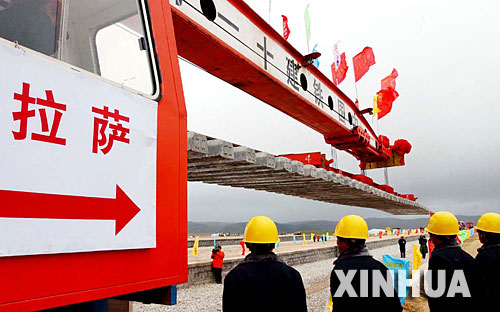 西藏境內第一段鐵路軌排在安多火車站鋪下,鐵軌將從這裡向拉薩繼續延伸(2004年6月22日攝)。 青藏鐵路從西寧至拉薩全長1956公里,是世界上海拔最高、線路最長、穿越凍土里程最長的高原鐵路。把鐵路修進西藏是幾代中國人的夢想,但這一想法直到新中國成立後才逐漸變為現實。青藏鐵路一期工程西寧至格爾木段于1958年開工,1984年交付營運。但限于當時國家的經濟實力以及高原、凍土等築路技術難題尚未解決,格爾木至拉薩段被迫停建。2001年6月,國家總投資330.9億元動工修建青藏鐵路二期工程。這一工程跨越崑崙山、唐古拉山,通過多年凍土層和大片“生命禁區”,是人類鐵路建設史上亙古未有的穿越。它的建成將為神秘而古老的青藏高原帶來新的生機和活力! 新華社發